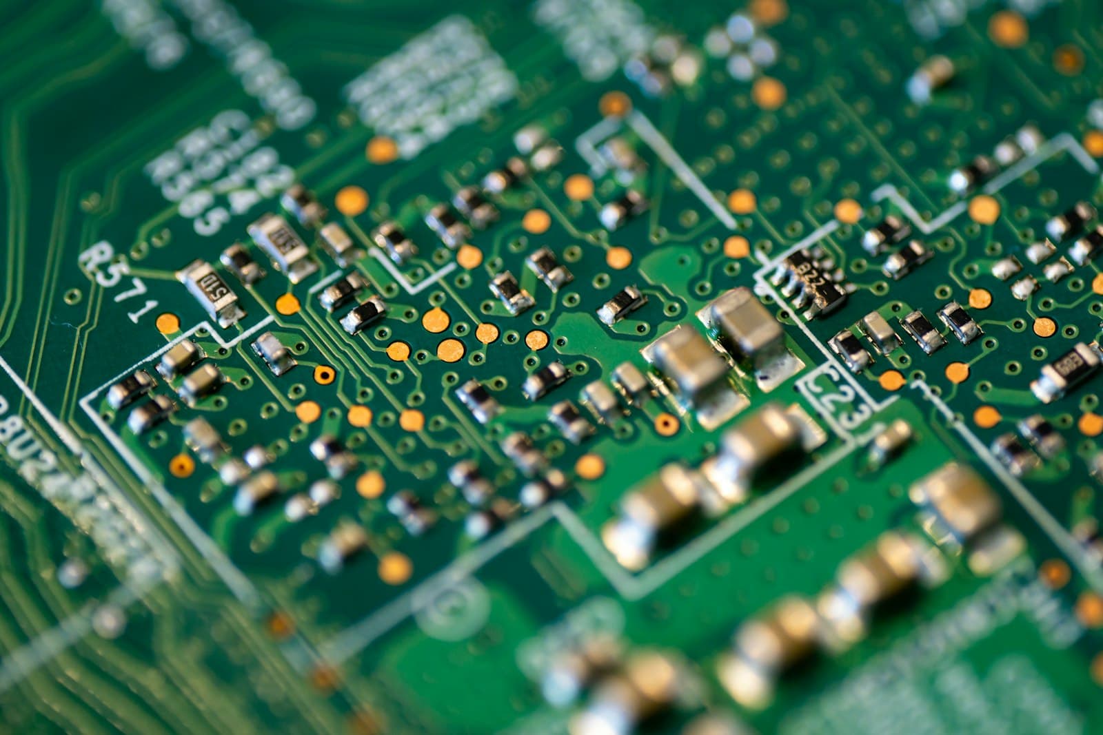 Macro close-up of a green and gold printed circuit board showing chipset pathways